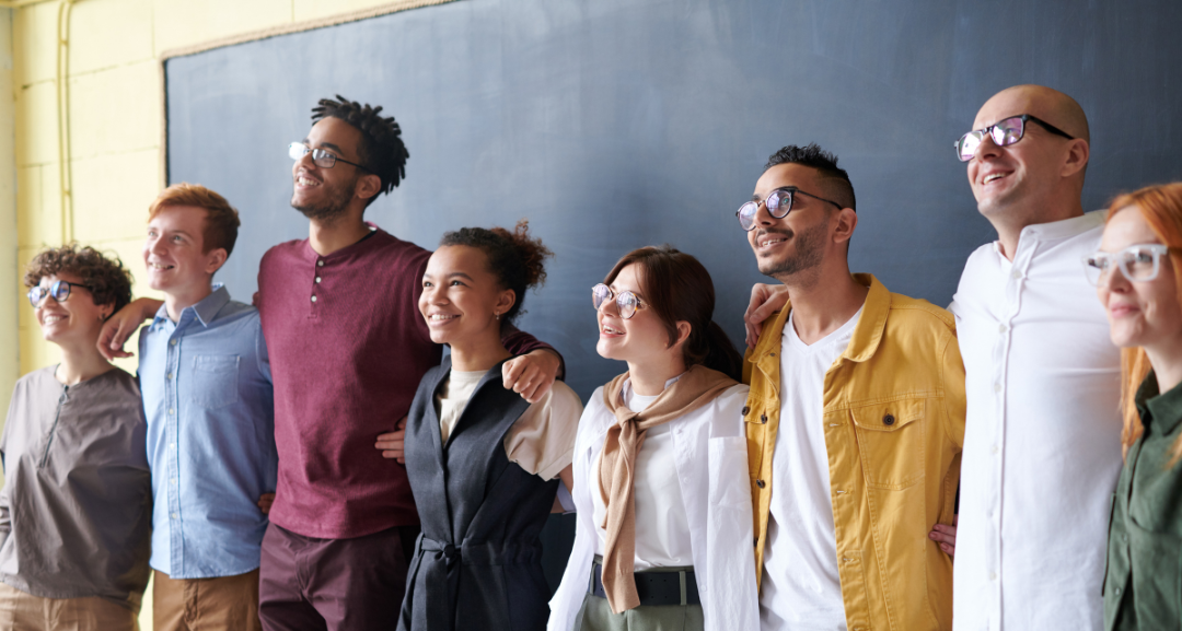 Aspiring teachers standing together in front of a chalk board.