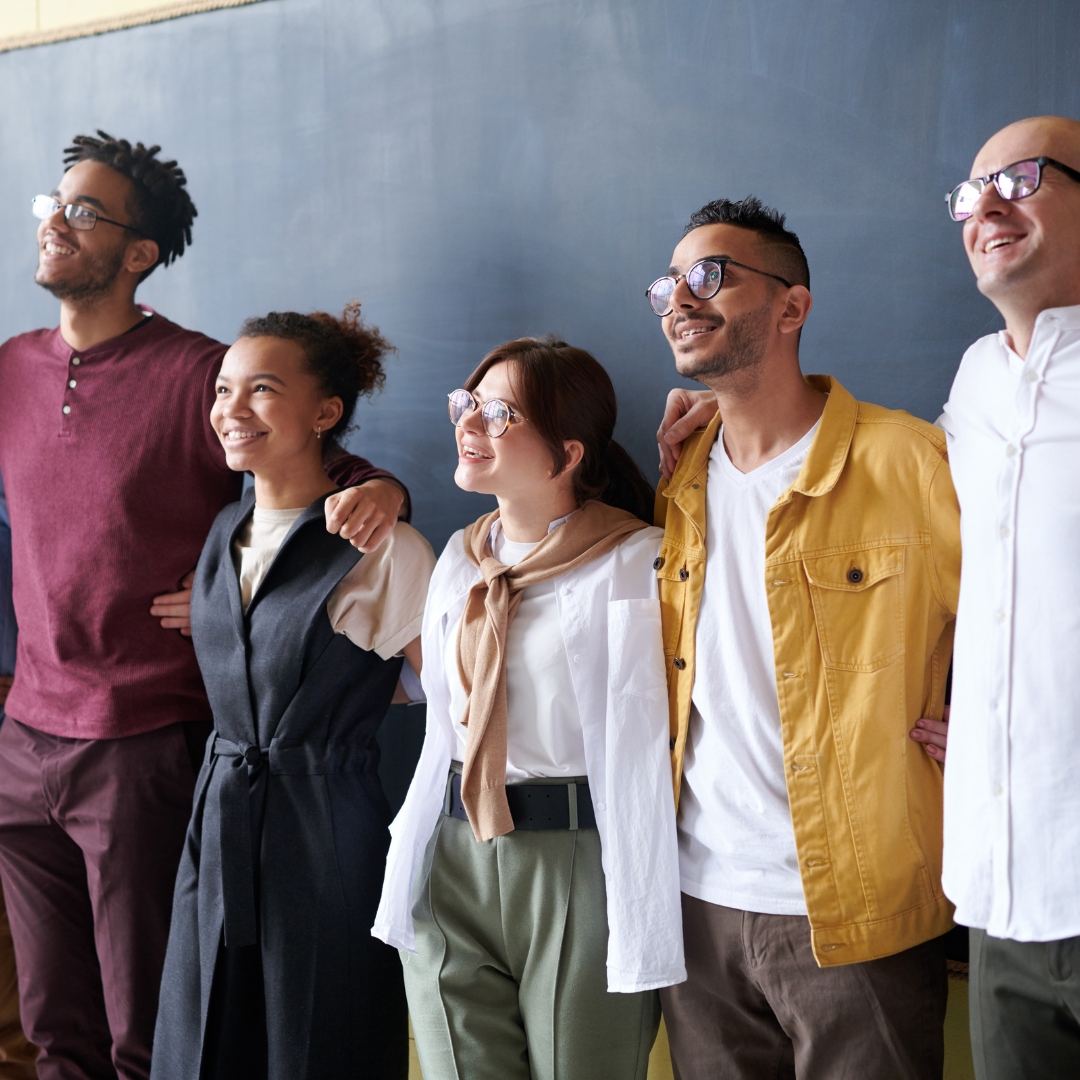 Aspiring teachers standing together in front of a chalk board.