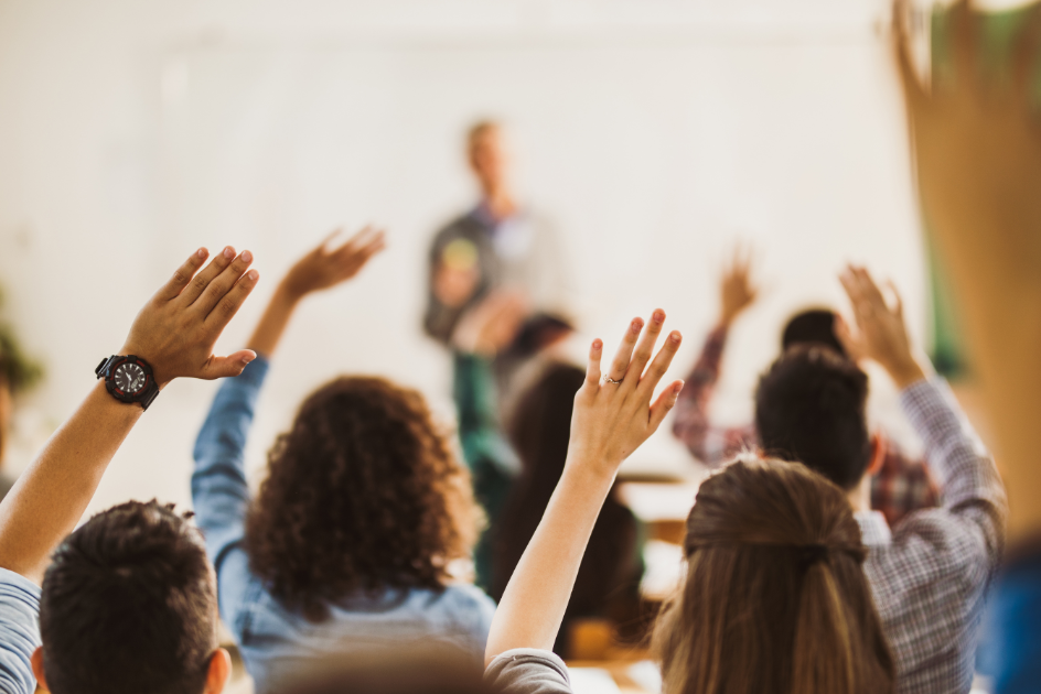 Teachers raising their hands to volunteer to be mentors.