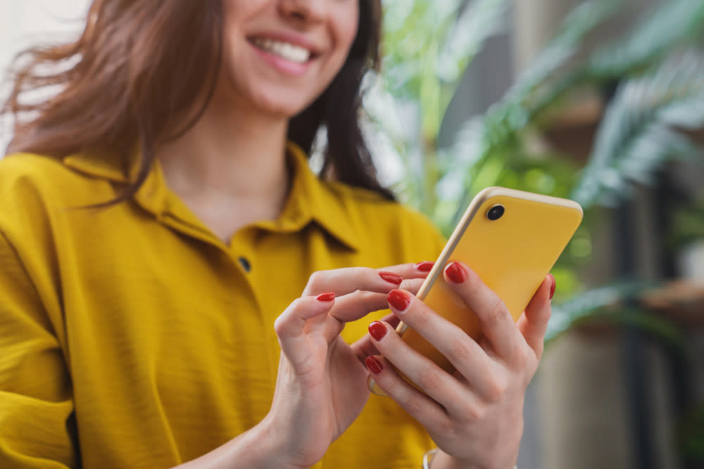 Cropped image of a girl using smartphone device 