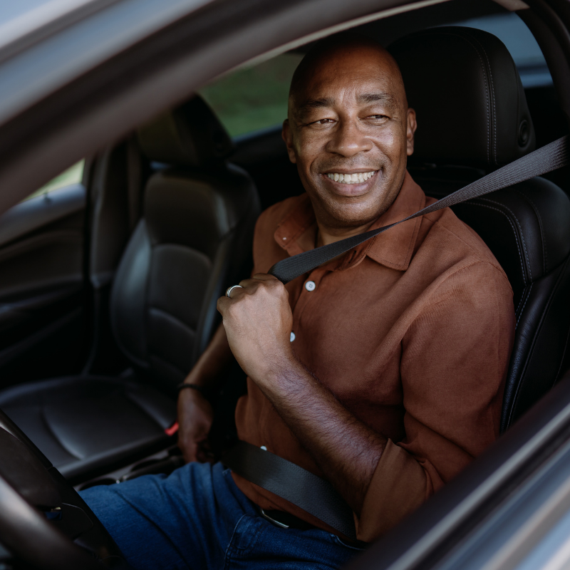 Man smiling driving car