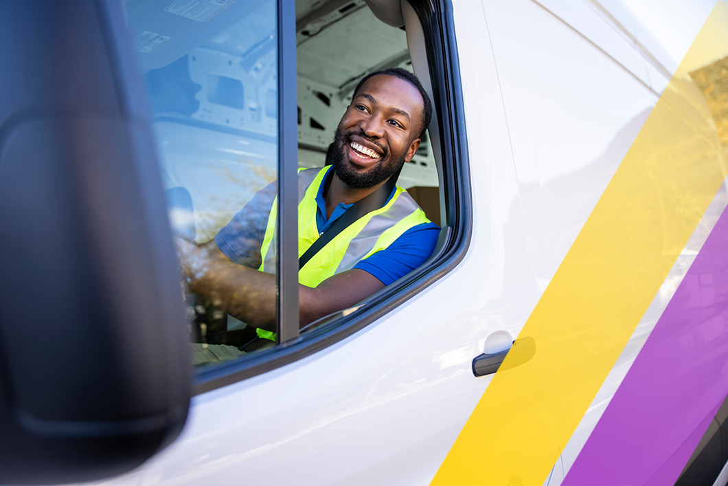 A man wearing a safety vest driving a sprinter van.