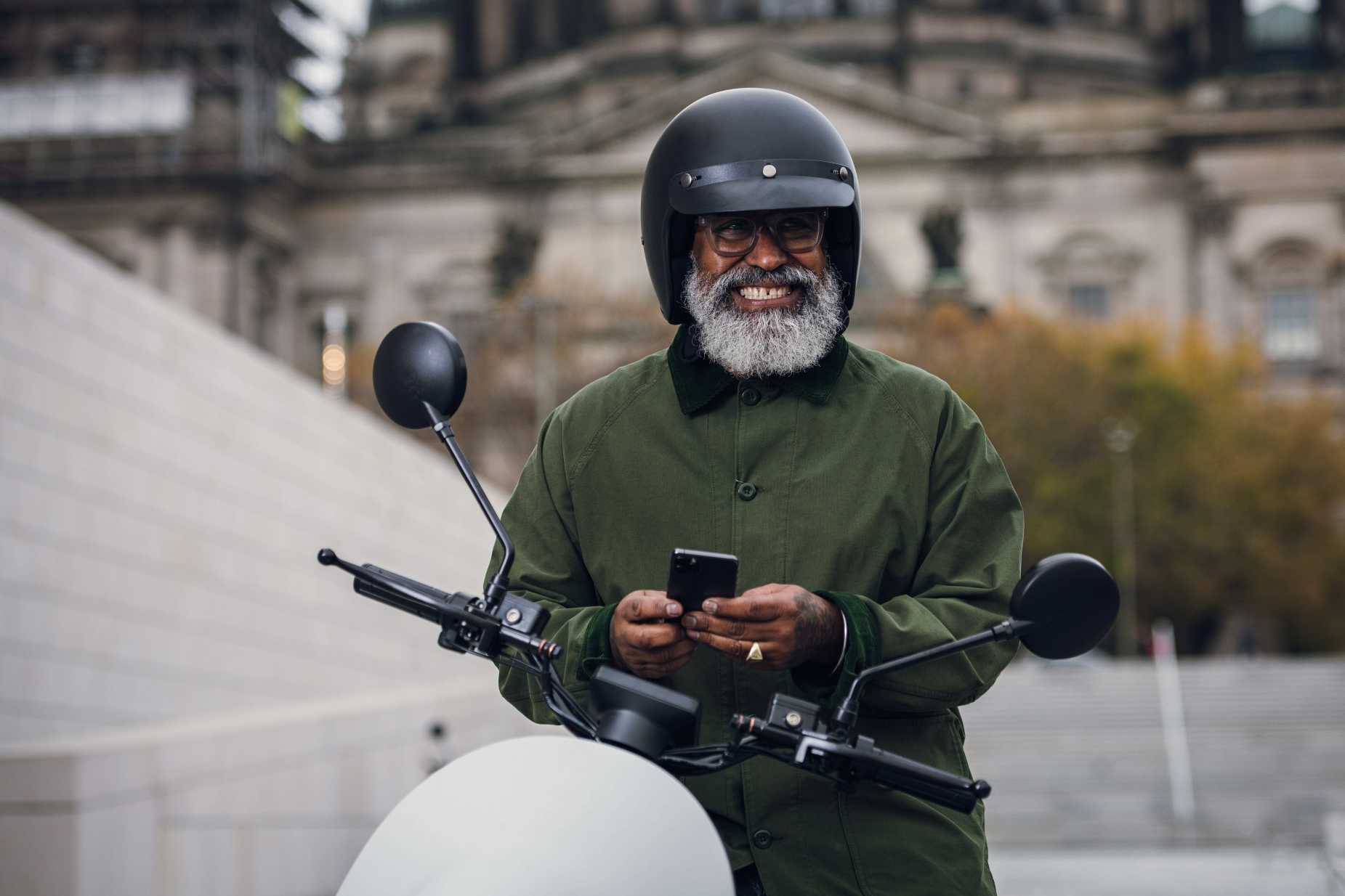 man on white unu e-scooter with helmet