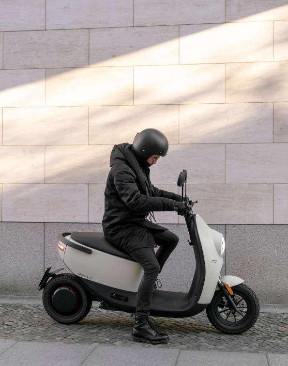 Person with helmet on white scooter