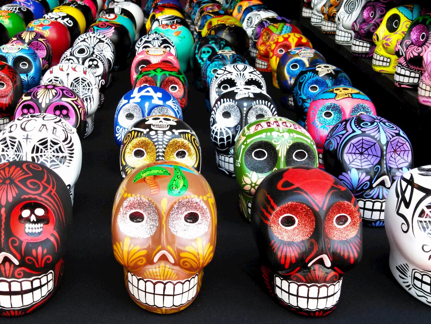 ​​Sugar skulls with a variety of paint colors and design on a table