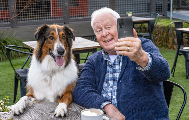 A man takes a selfie with his dog using the Jitterbug Smart4. 