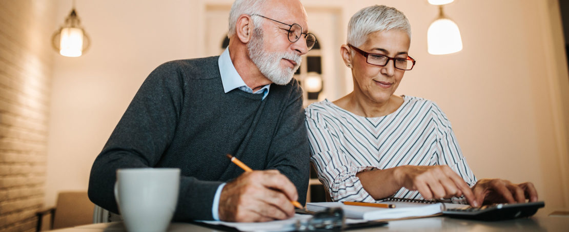 Older couple sitting at counter reviewing finances together