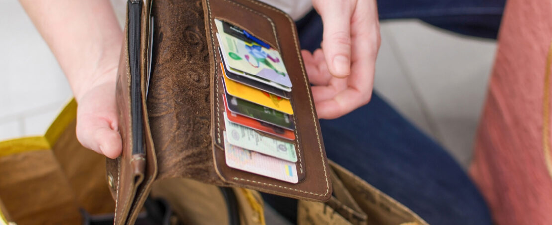 woman holding open her wallet full of credit cards