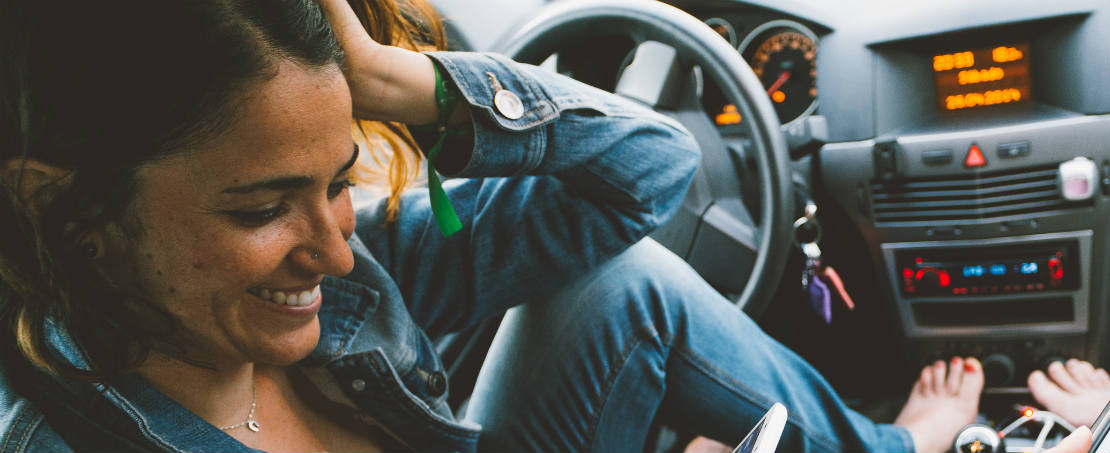 woman looking at phone in car