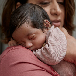 Mother holding sleeping baby