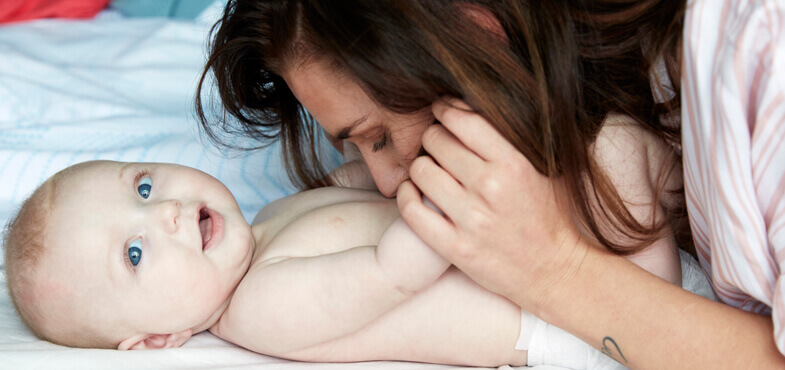 mother kissing baby's stomach