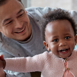 father holding baby's hands