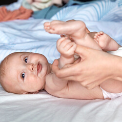 baby lying on bed smiling