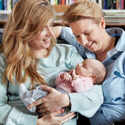 two mothers holding baby