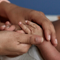 mother holding baby hand