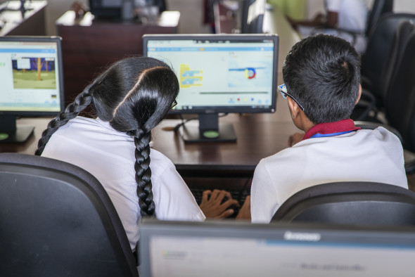 A boy and girl working together on a programming project