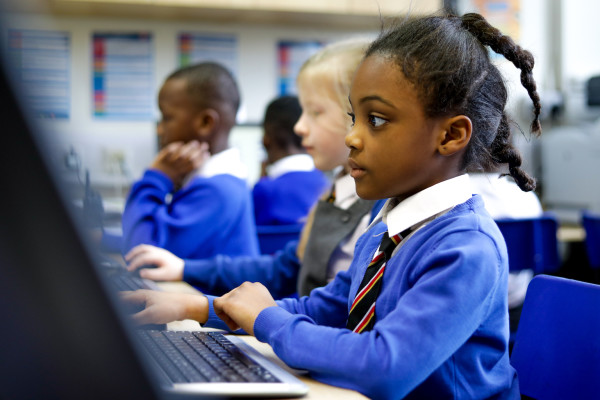 Learners at keyboards in a primary school computing classroom.