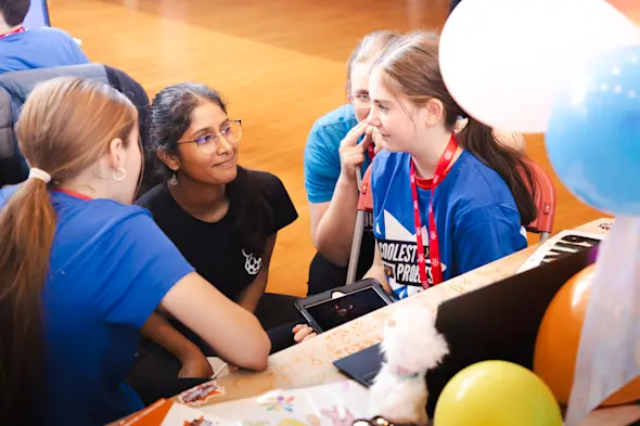 Young people tell an adult about their tech creation at Coolest Projects.