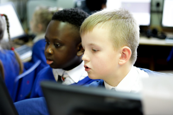 Two primary-aged children working together at a computer