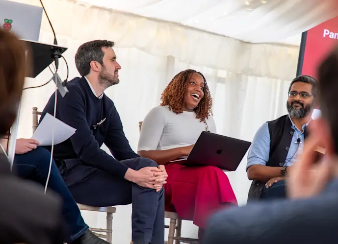 Three people on stage at a panel discussion.