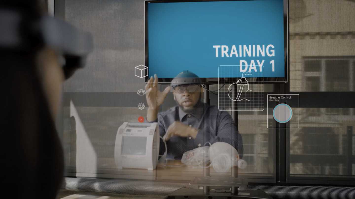 Hologram of a man giving training in a physical product, with holograms of images in front of him.