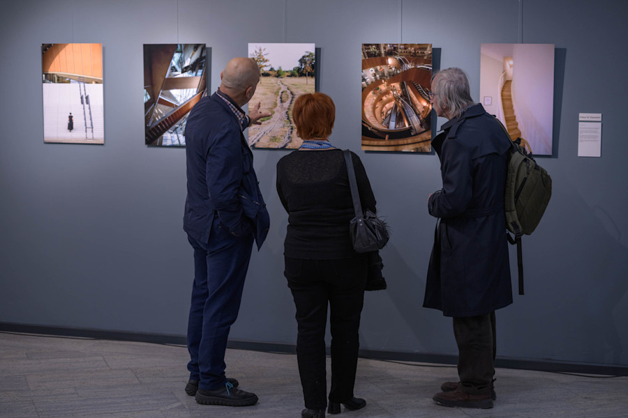 20260410 - KEA6915 Kopyası Fevzi ve ziyaretçiler, Klaus'un fotoğraflarının önünde