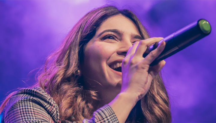 A female singer is performing at a live concert event