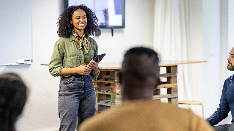 An employee is presenting information in a company team meeting.