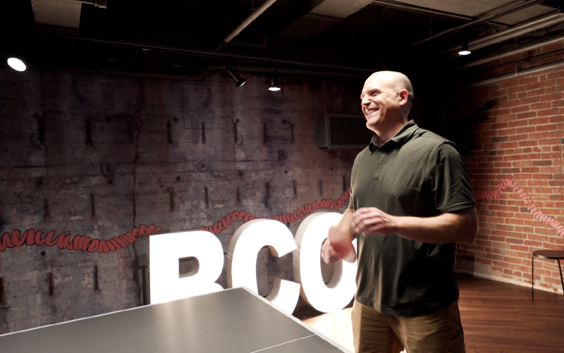 Brightcove employees are enjoying a game of ping pong at a global office.