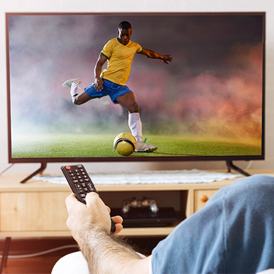 Person watching soccer video stream on a tv