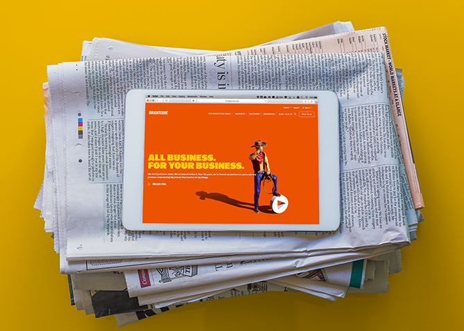 Une tablette affichant une page Web au-dessus d'une pile de journaux