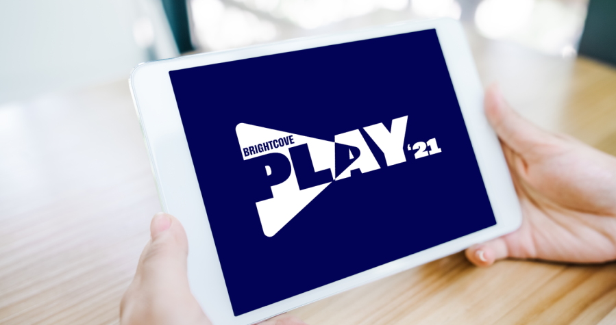 hands holding a tablet displaying the PLAY 2021 logo
