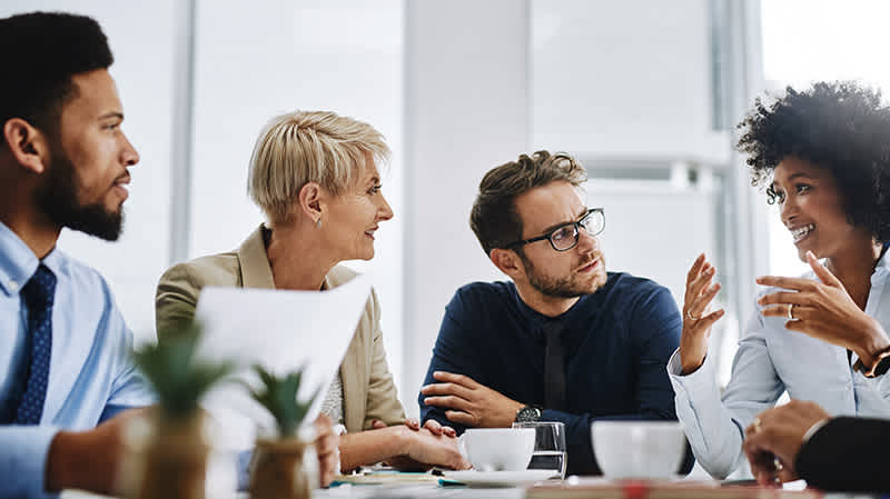 A team is having a meeting in a room to collaborate and share ideas.