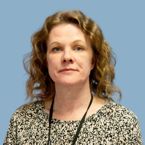 A woman with wavy hair and a key ribbon on her neck