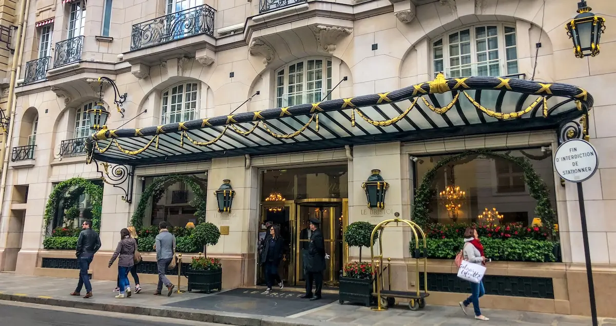Exterior of the hotel Le Bristol in Paris, showing two doormen waiting outside the lobby.