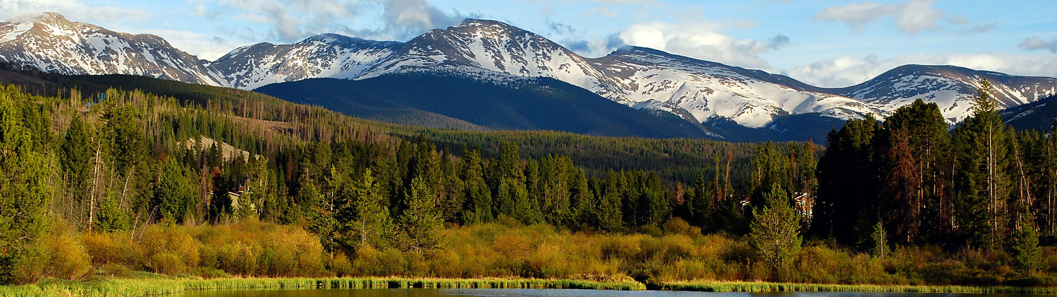 Green valleys and slopes lie before the imposing peaks of Winter Park.