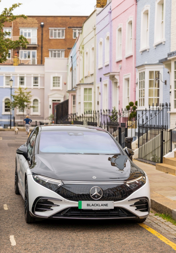 A Blacklane Mercedes EQS limousine parked in front of a row of colourful houses in London's Chelsea.