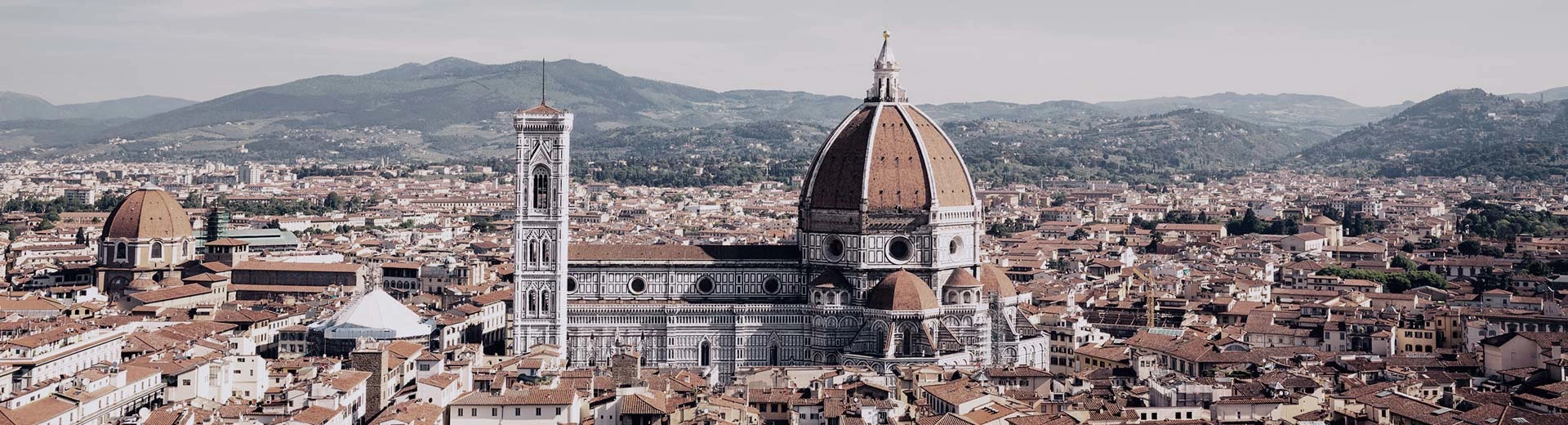 The beautiful skyline of Florence on a clear and warm day. Dominating the area is a large and beautiful cathedral.
