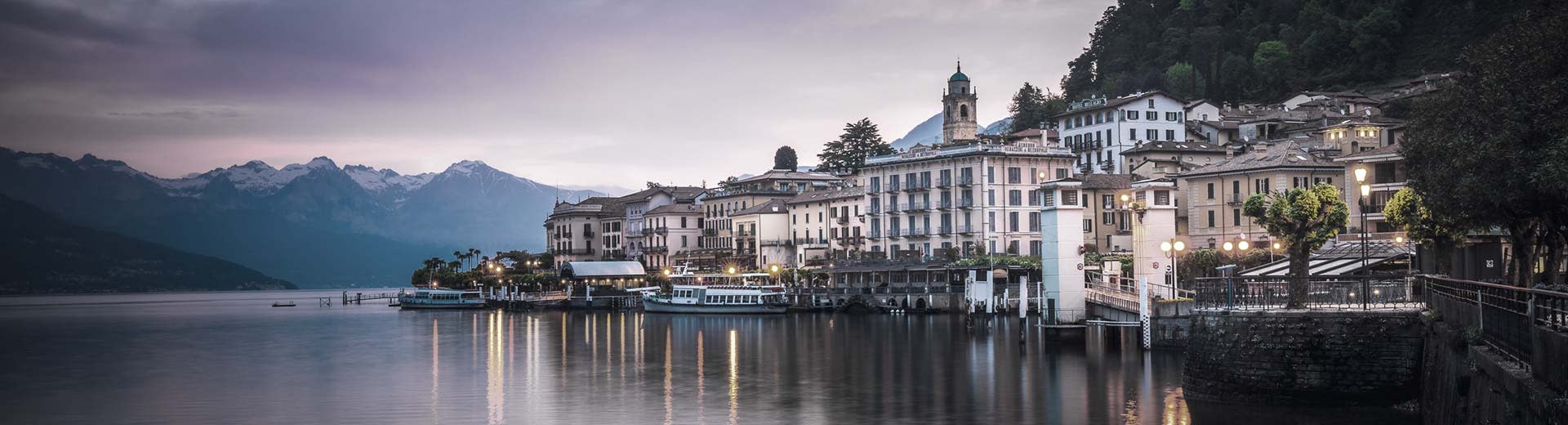 El hermoso edificio de Como se alinea en la orilla del lago a media luz.