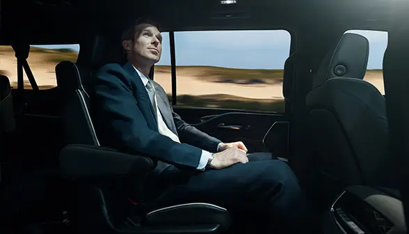 A smartly dressed passenger inside a Blacklane business van.