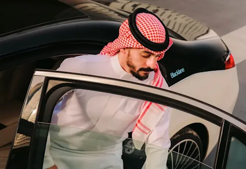 Close-up of a man in traditional Saudi dress exiting a Blacklane Mercedes limo.