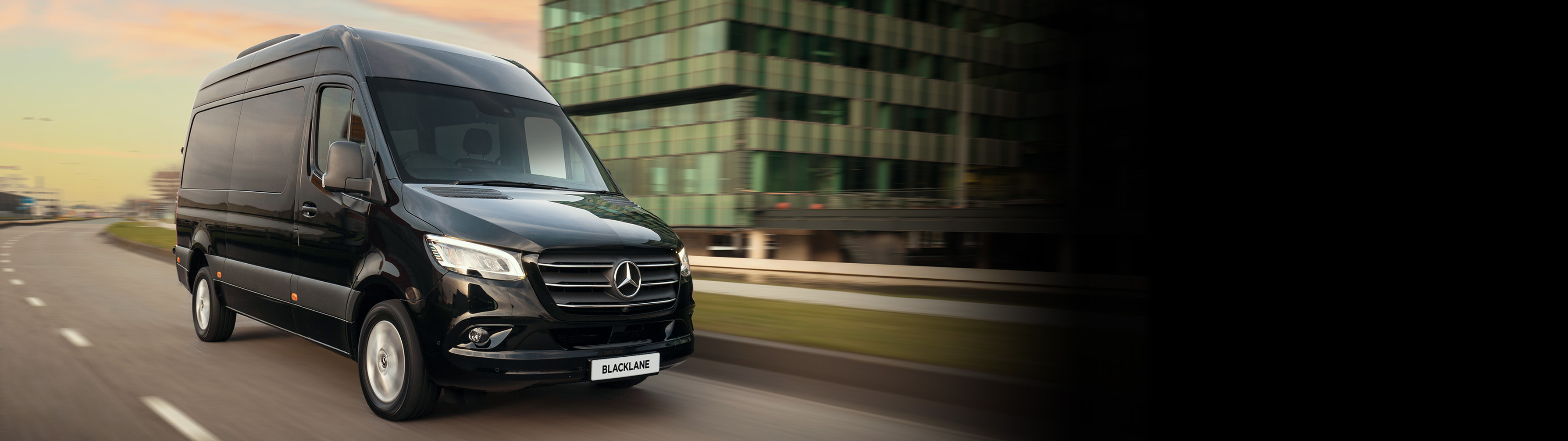 A black Mercedes Sprinter Van driving down the road.