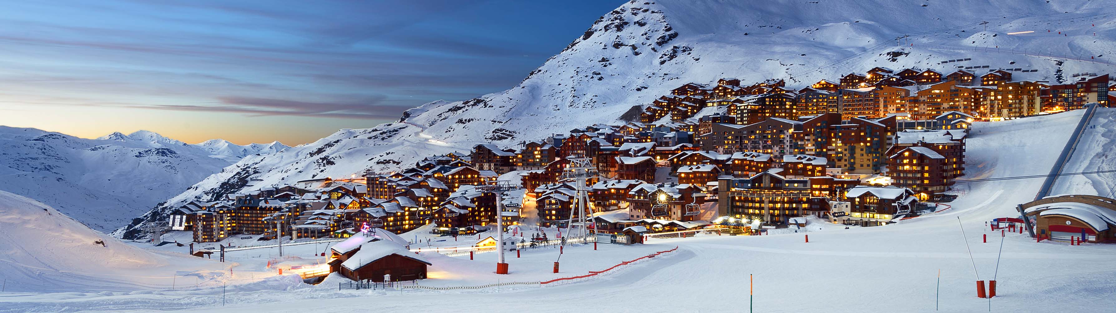 The white slopes and chalets of Val Thorens lit up at night.