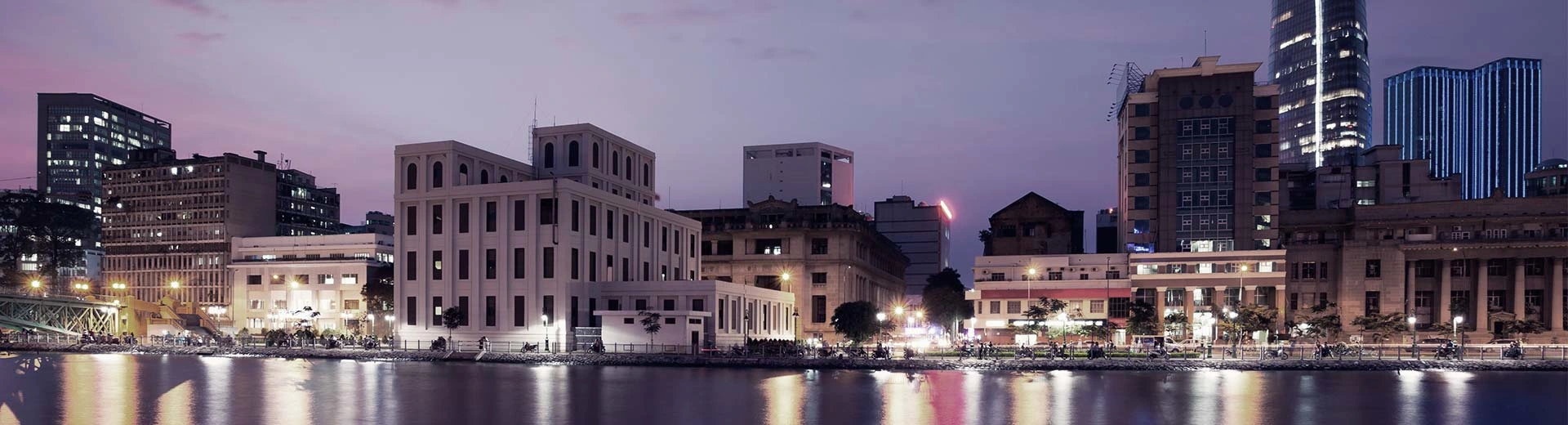 夕暮れ時か夜明けの光量が少ない時間帯のホーチミンの水辺の風景。