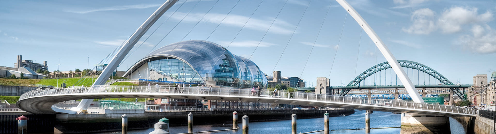 A view of the Gateshead Millennium Bridge with Sage Gateshead culture center in the background.