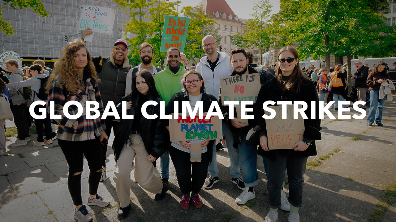 A group photo of nine Blacklane crew members holding up protest signs at a global climate strike. White text overlays the image and says 'Global Climate Strike'.
