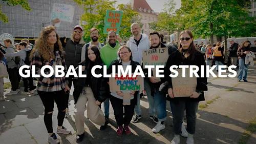 A group photo of nine Blacklane crew members holding up protest signs at a global climate strike. White text overlays the image and says 'Global Climate Strike'.
