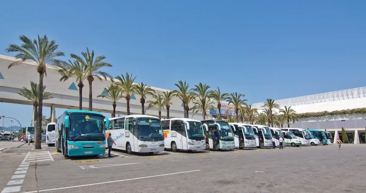 Buses and coaches outside Palma de Mallorca Airport with the terminal building in the right background.
