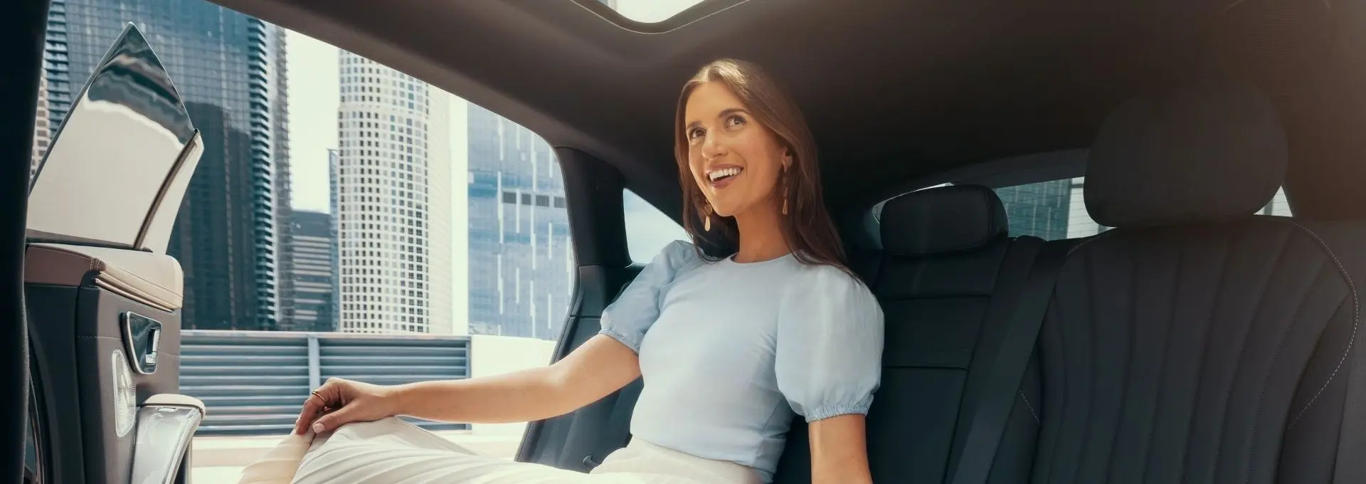 A woman sits in the back seat of a Blacklane luxury limo.