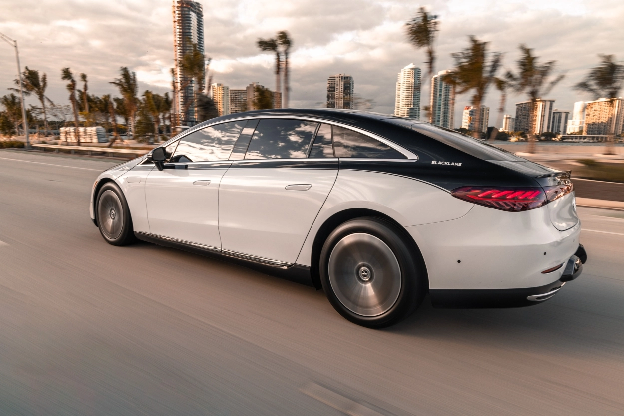 A black-and-white Blacklane limousine speeds along the road in Florida.